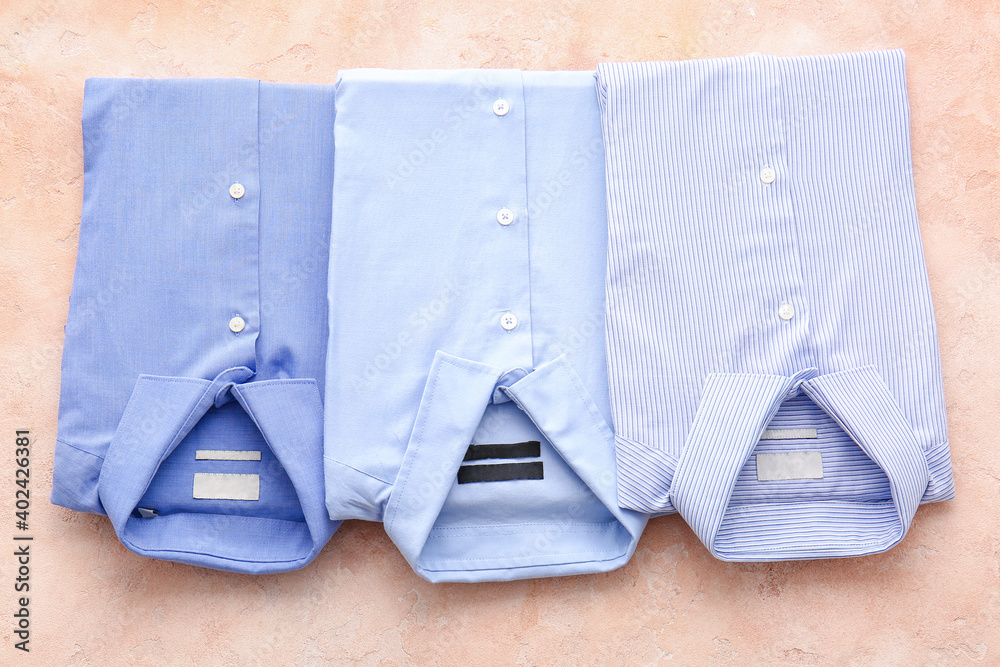 Folded male shirts on light background