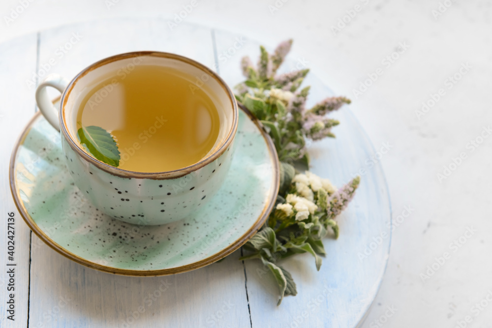 Cup with herbal tea on light background