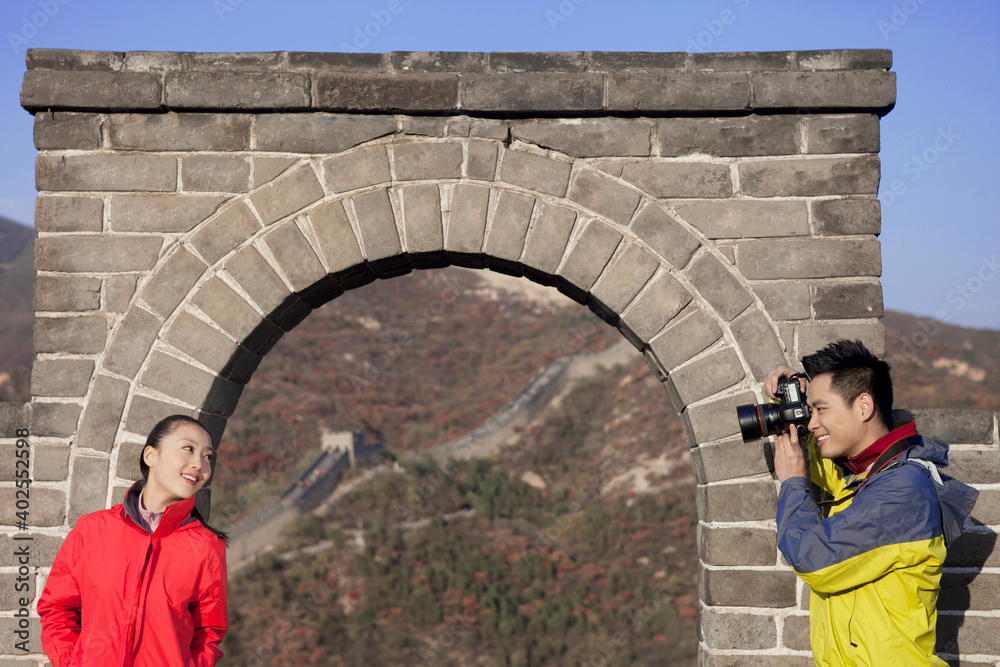 年轻情侣在长城旅游合影