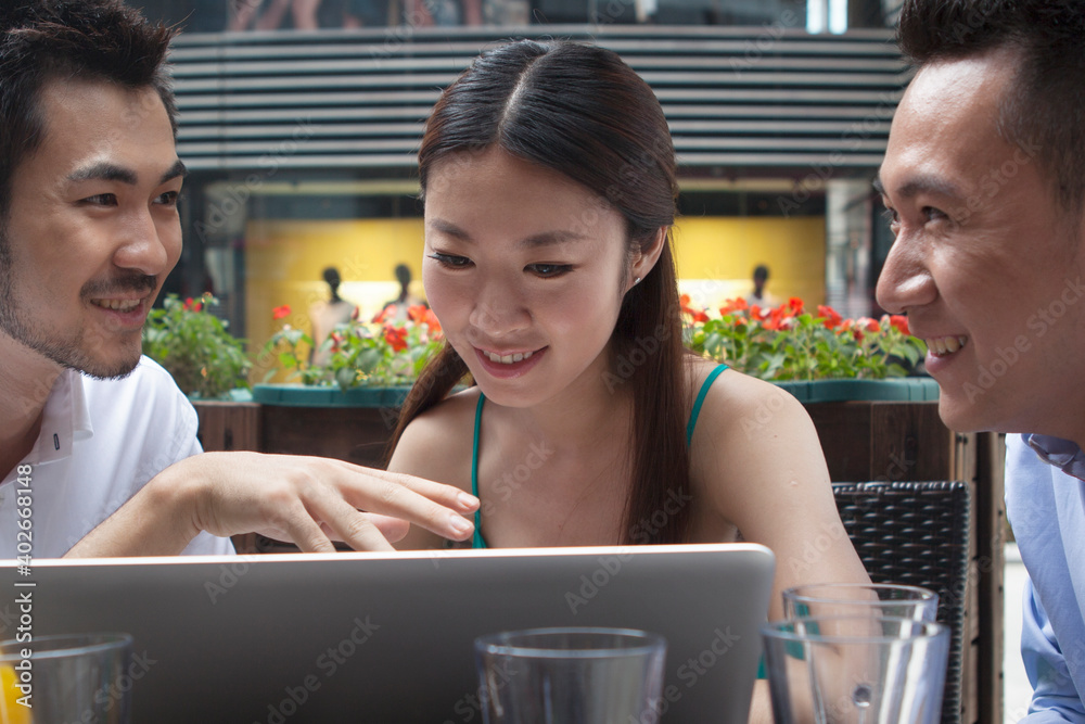 Three people sit together working with computers 