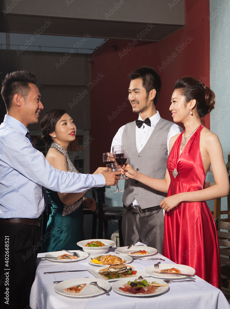 Four people sit together for dinner and chat