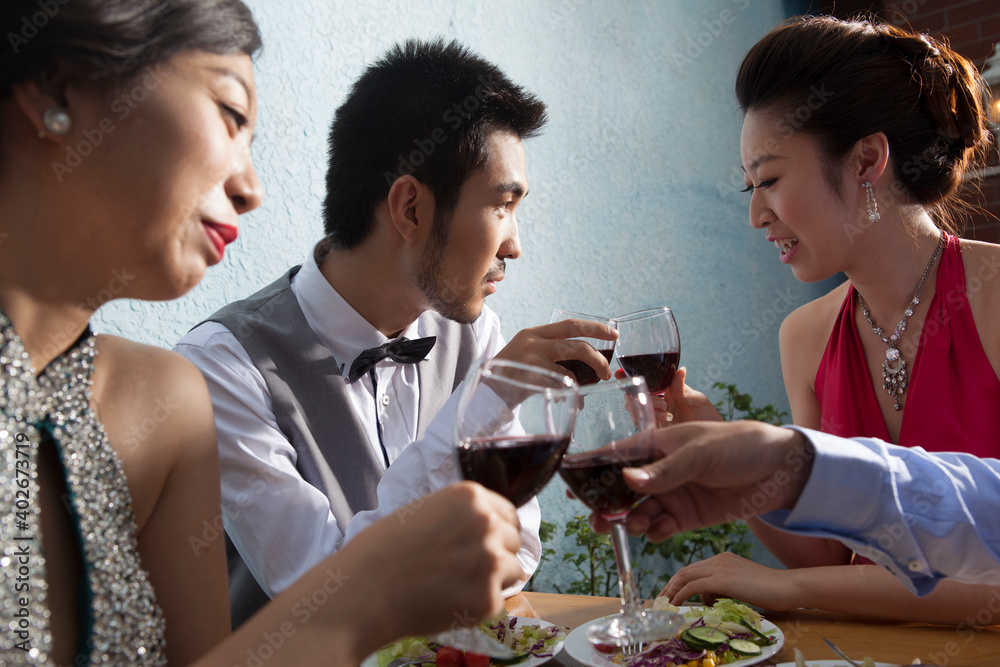 Four people sit together for dinner and chat 