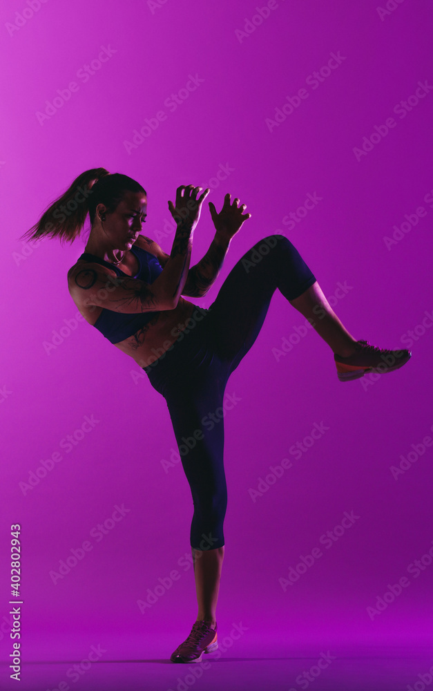 Fit woman working out on purple background