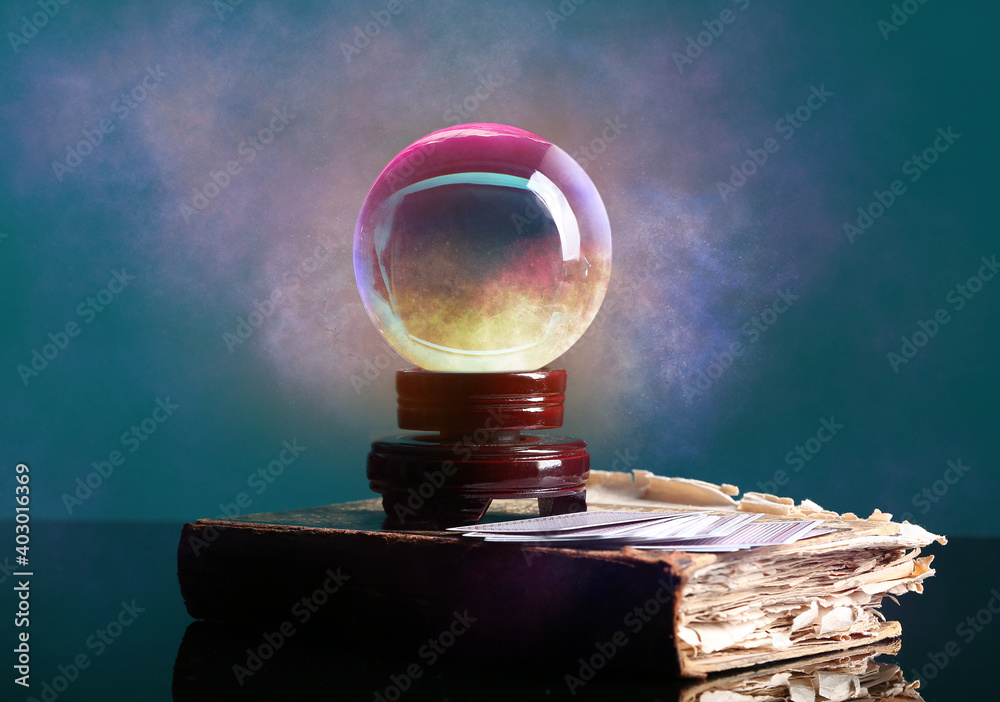 Spell book, crystal ball of fortune teller and cards on table