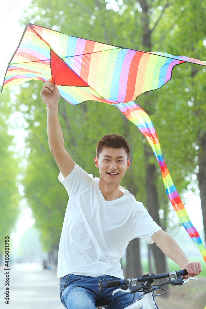 A young man flying a kite in the park