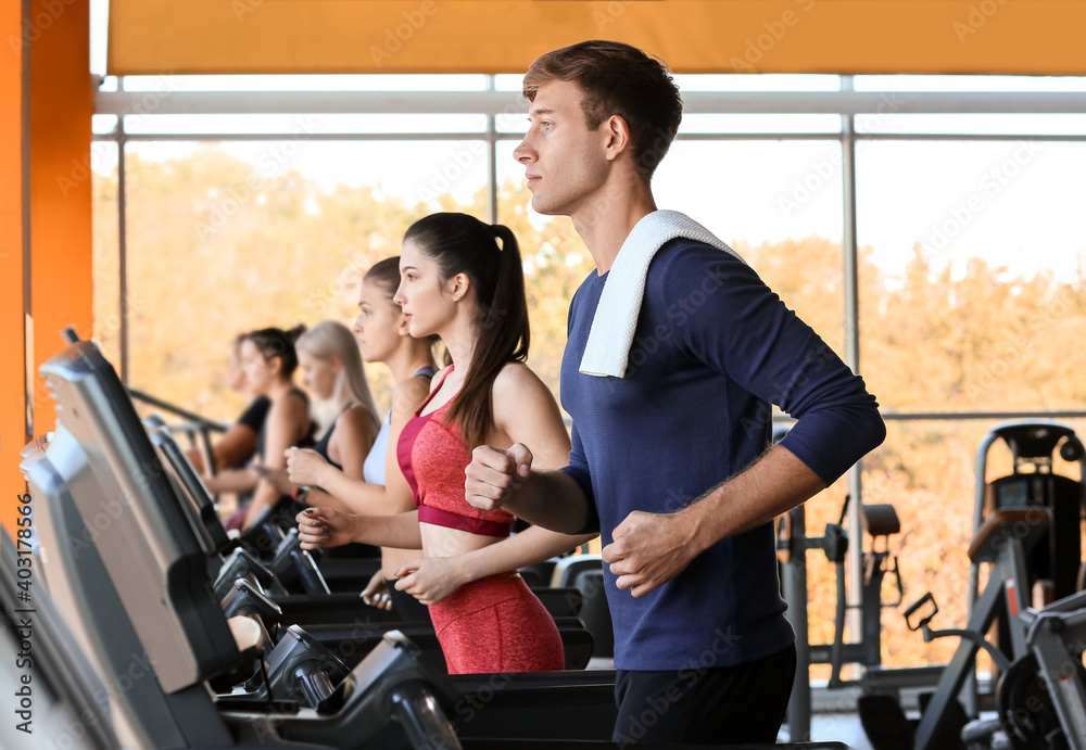 Young people training on treadmills in gym