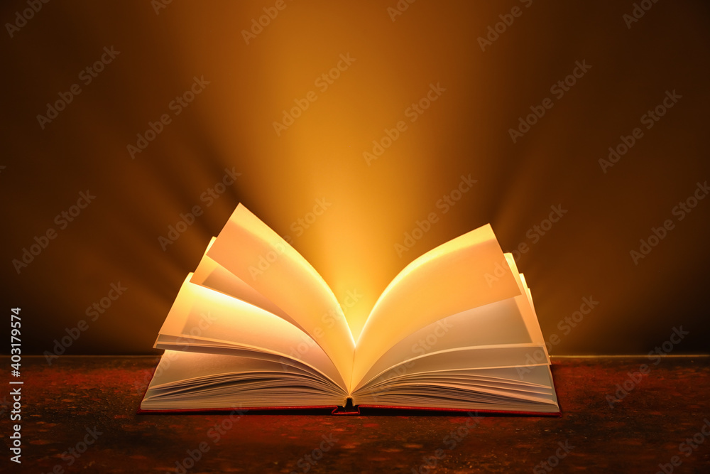 Open book on table against dark background