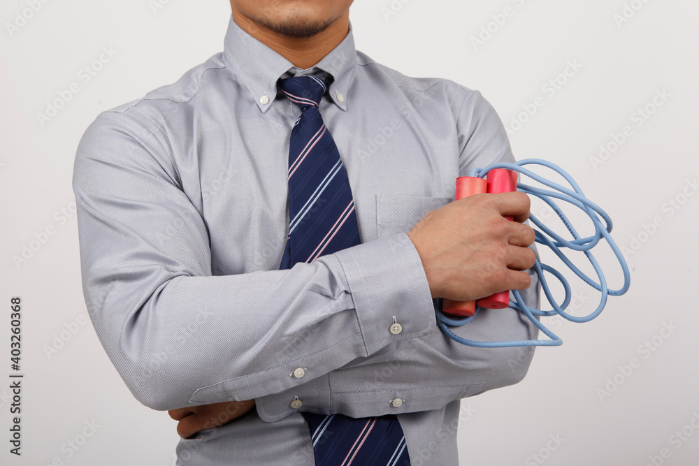 A young business man exercising with rope skipping 