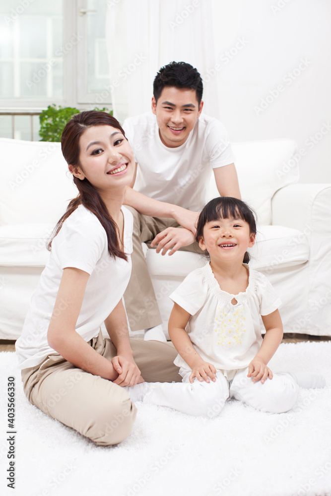 A happy family of three sitting in couch 