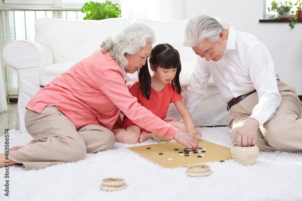 带孙女玩围棋的老年夫妇