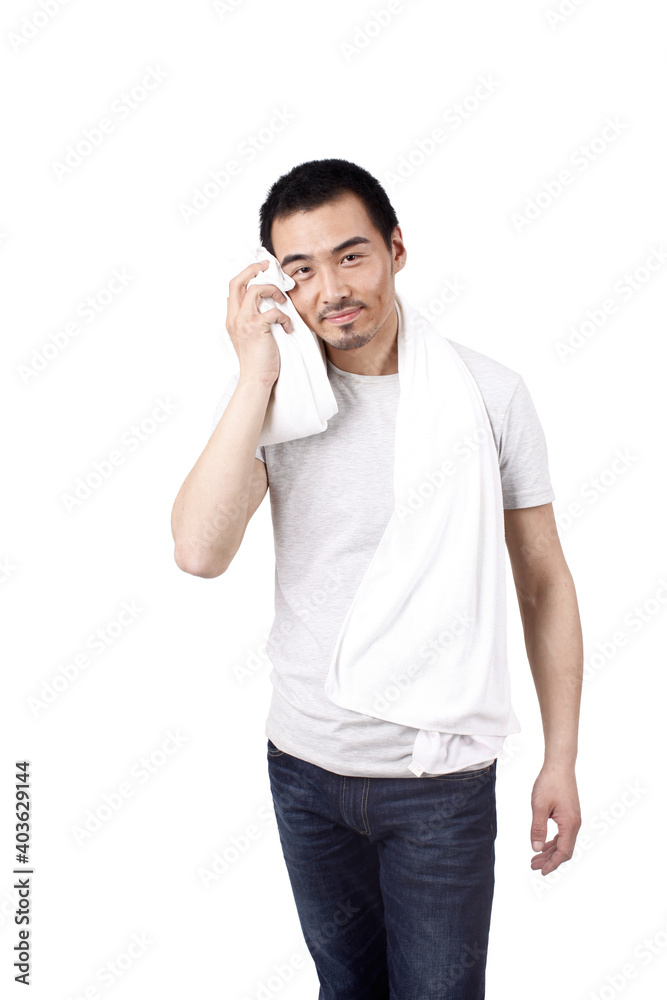 A happy young man wiping with towel 