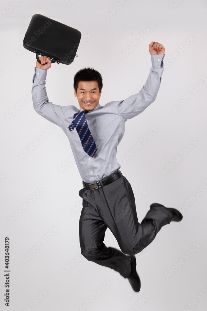 A young business man jumping with a briefcase