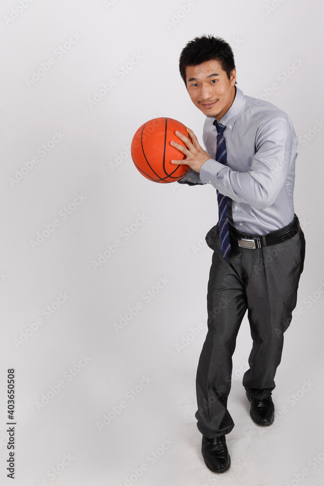 A business man exercising with playing basketball 