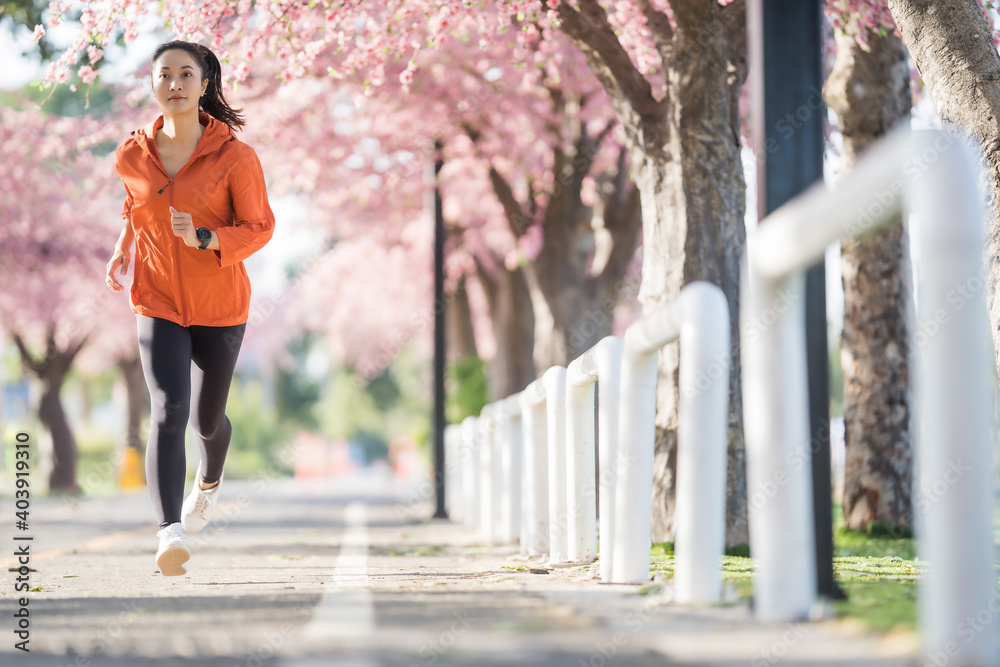 Asian woman exercise in the morning She is running at Sakura Park.