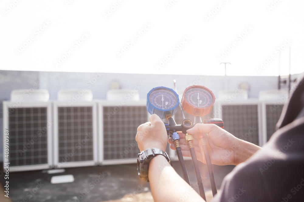 Technician is checking air conditioner ,measuring equipment for filling air conditioners.Cooling sys