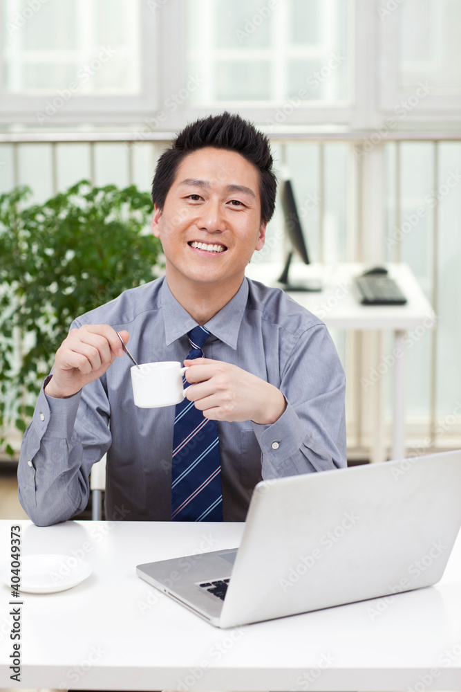 Close-up of a businessman using a laptop in an office