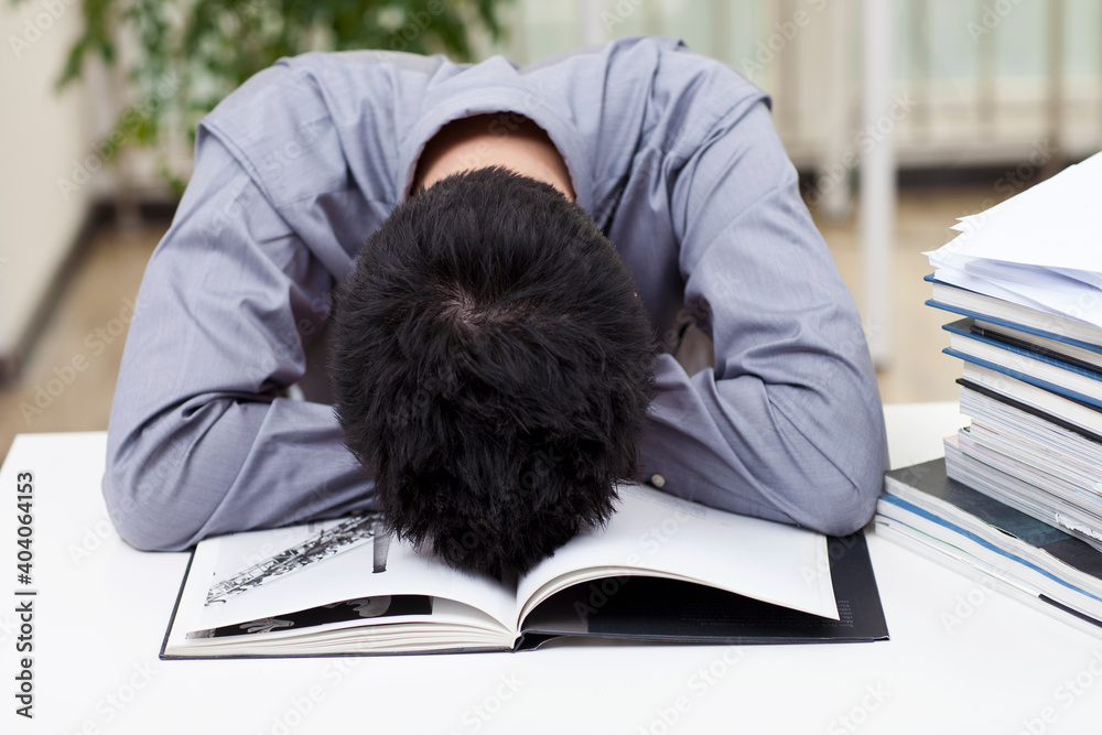 A man looks stressed as he works at his desk