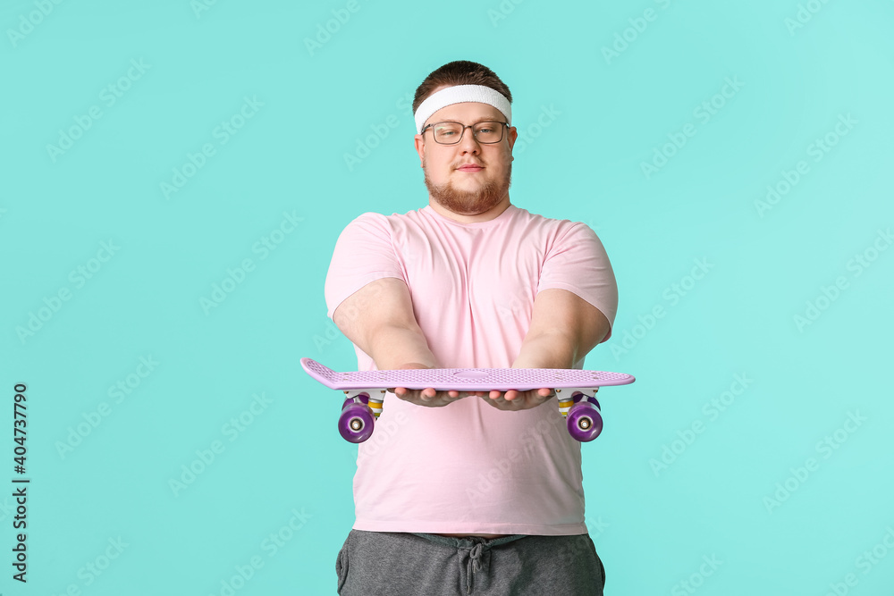 Overweight man with skateboard on color background. Weight loss concept