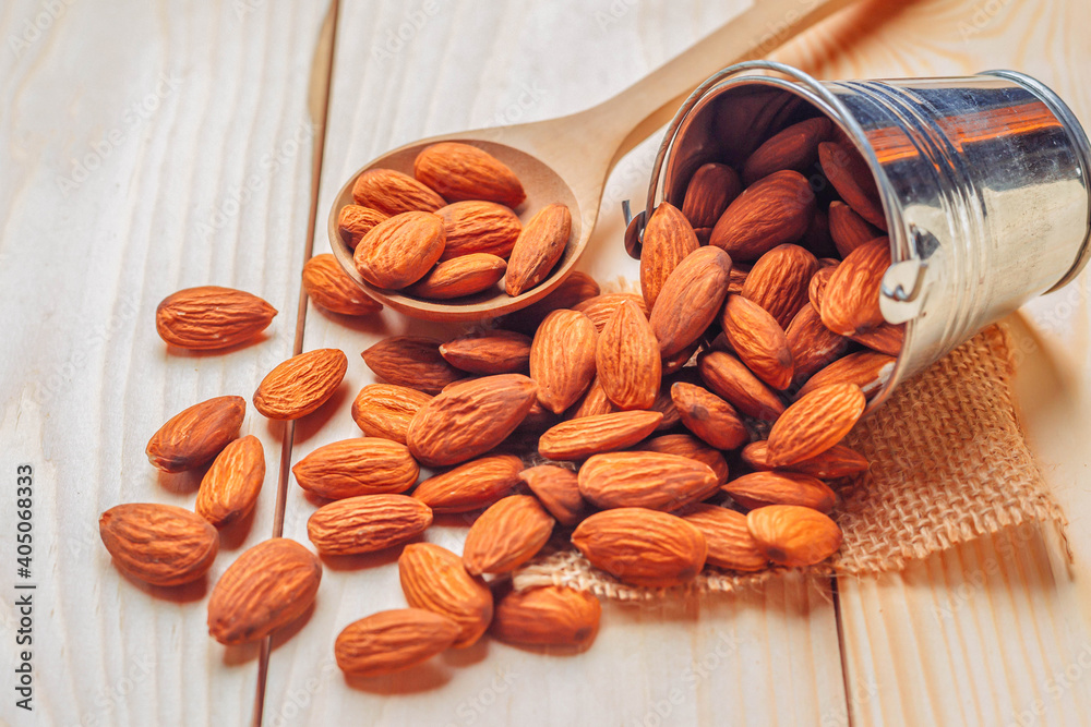 Almonds in bucket The nuts are freely placed on the dark board.