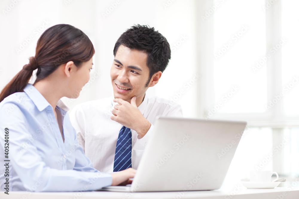 Businessman and businesswoman discussing working on computer