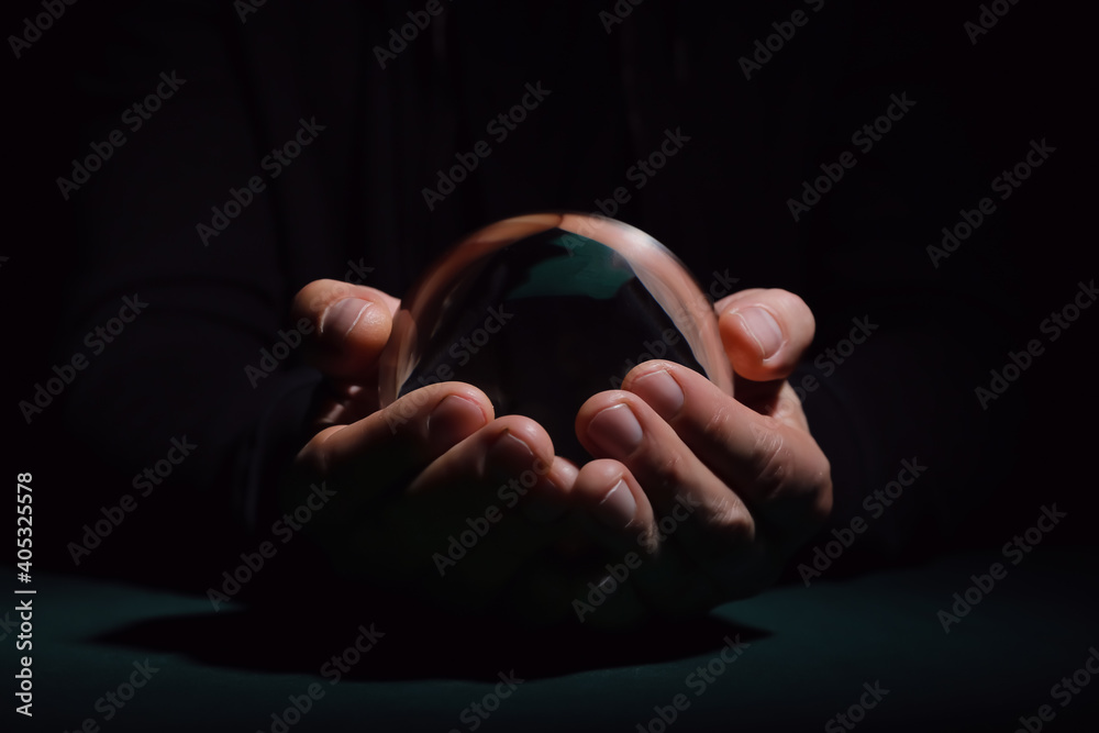 Fortune teller with crystal ball on dark background