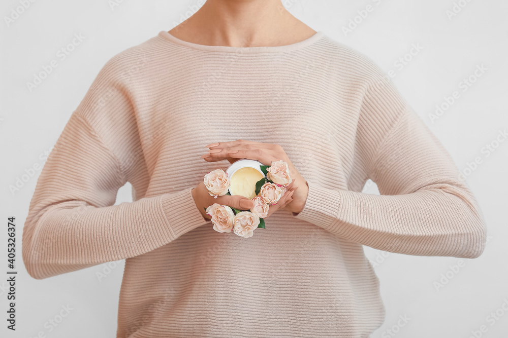 浅色背景下有奶油色和美丽花朵的年轻女子