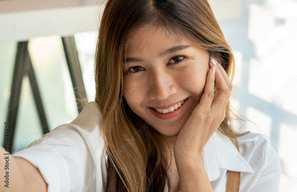 Beautiful businesswoman taking selfies while having free time from hard work within the office.