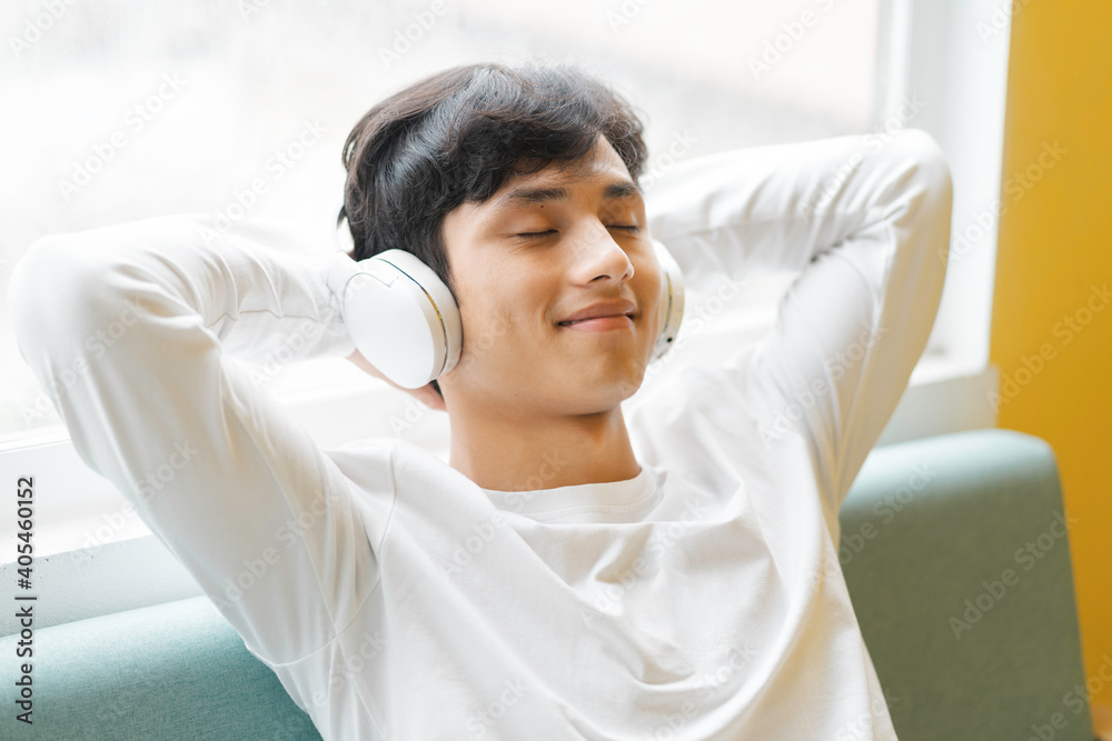 Asian man sitting, enjoying music