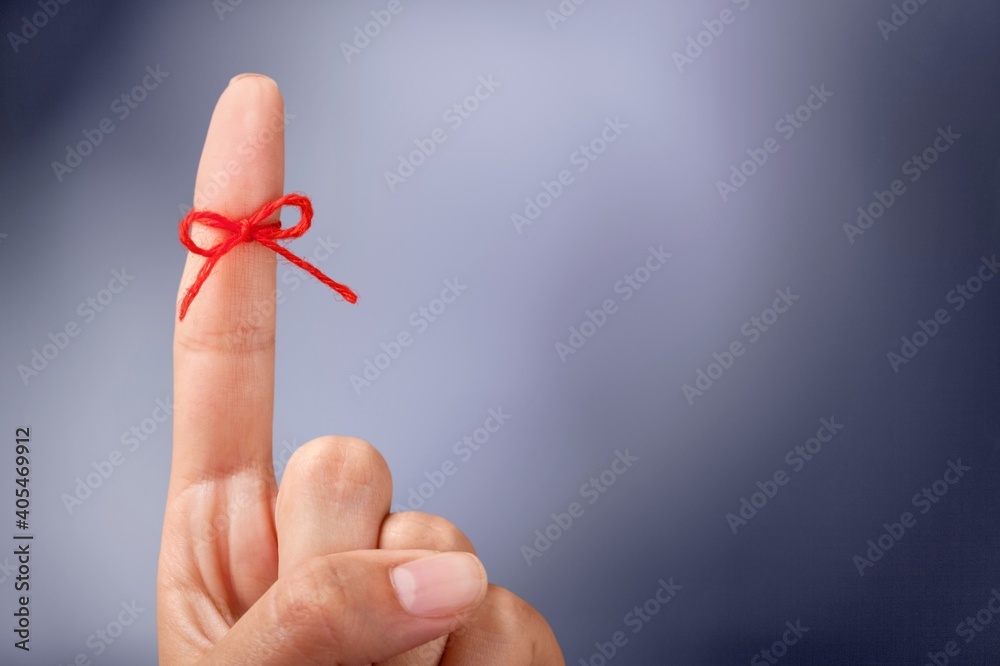 Red thread bow on a human finger