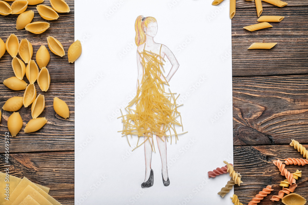 Drawn woman in dress made of pasta on wooden background