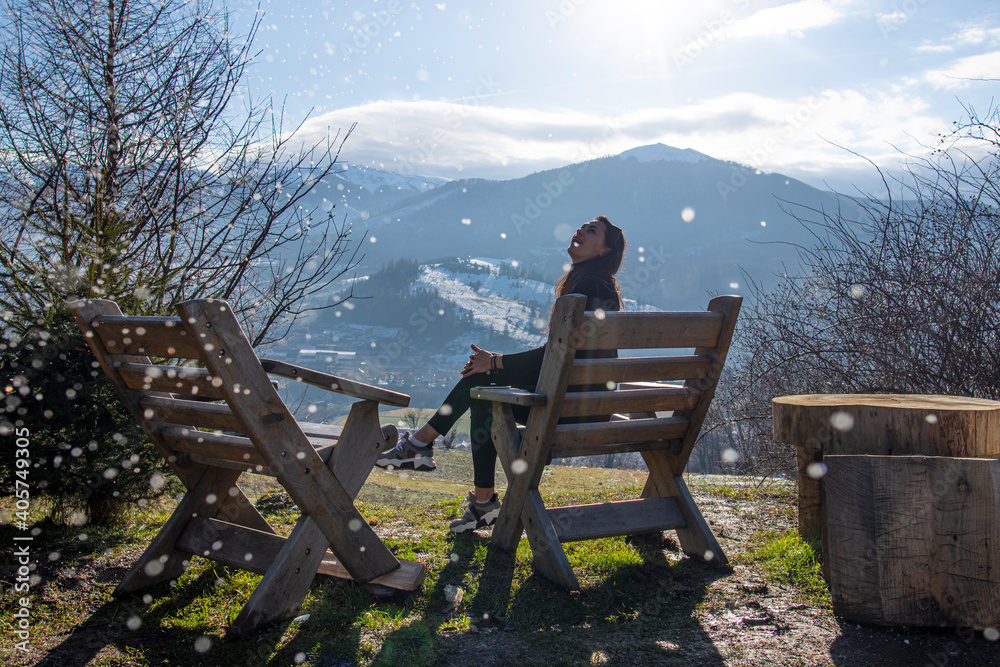 Young woman sitting in lounge chair in mountains