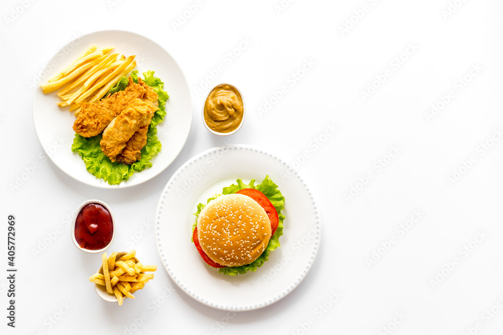 Burger and french fries with french fries and fried chicken, overhead view