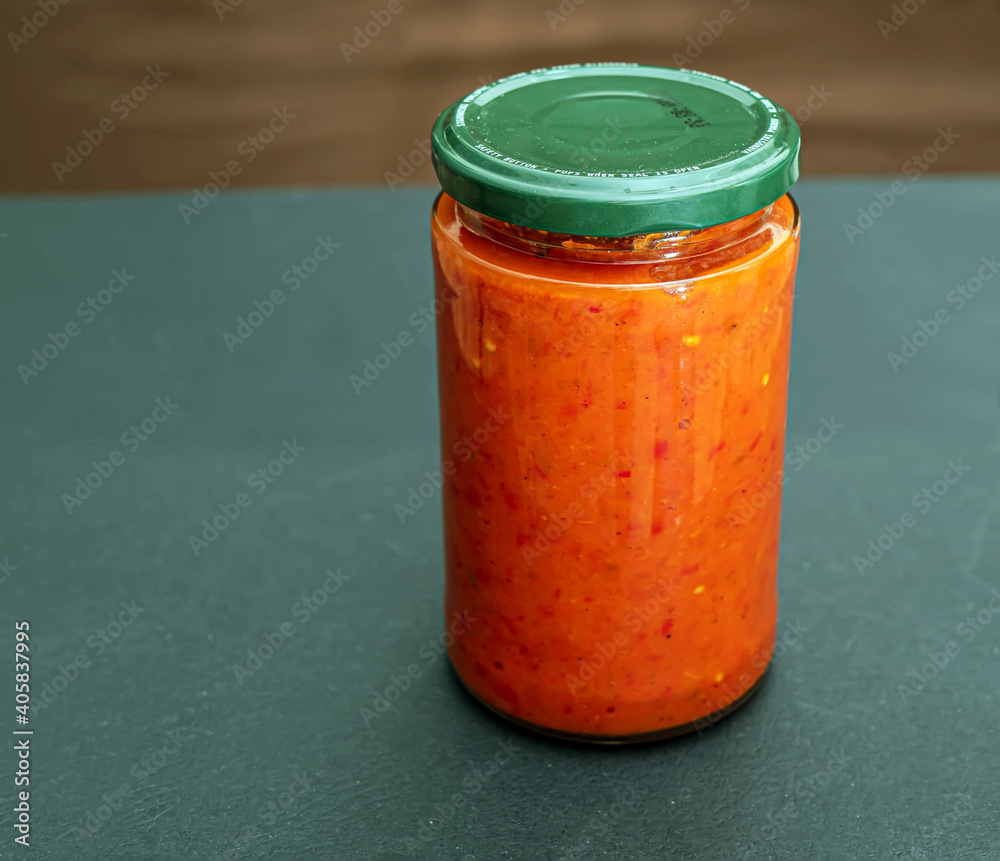 A glass can full of homemade ajvar. A baked bell peppers. South-European specialty. Mediterranean Ki