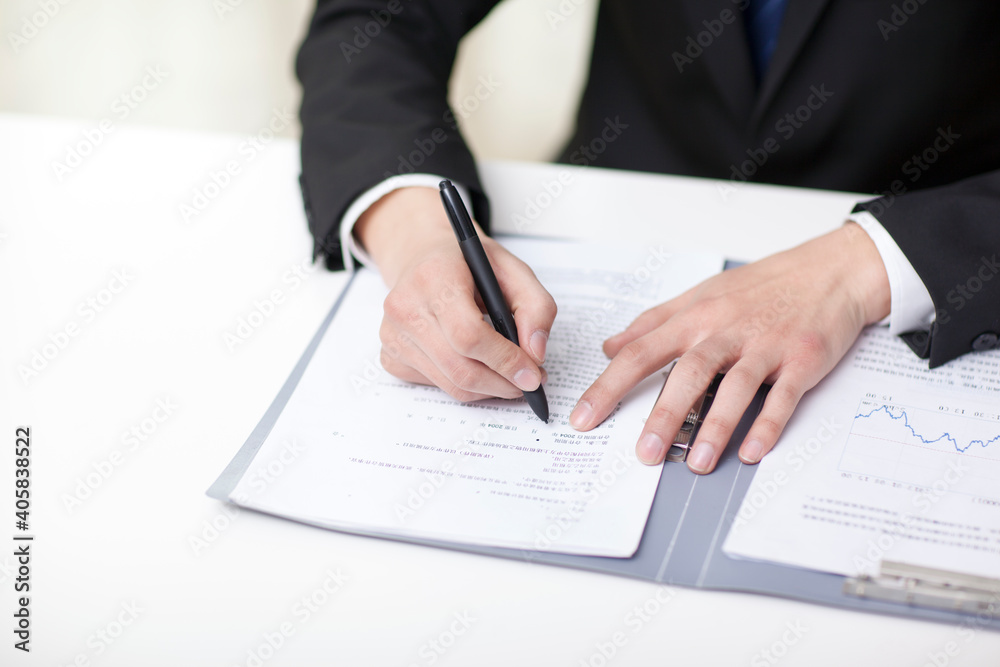 Portrait of young businessman writing in office