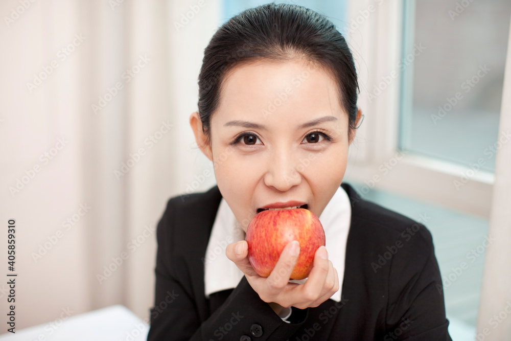 女商人在办公室吃红苹果