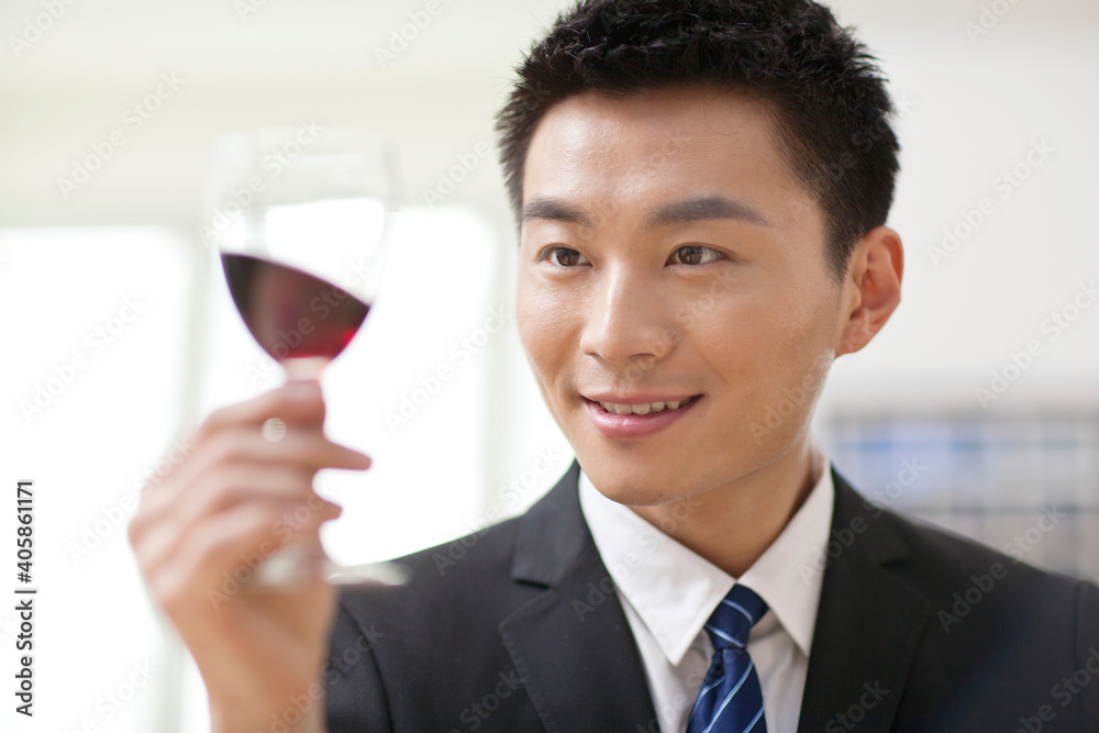 Portrait of businessman at desk with a glass of wine