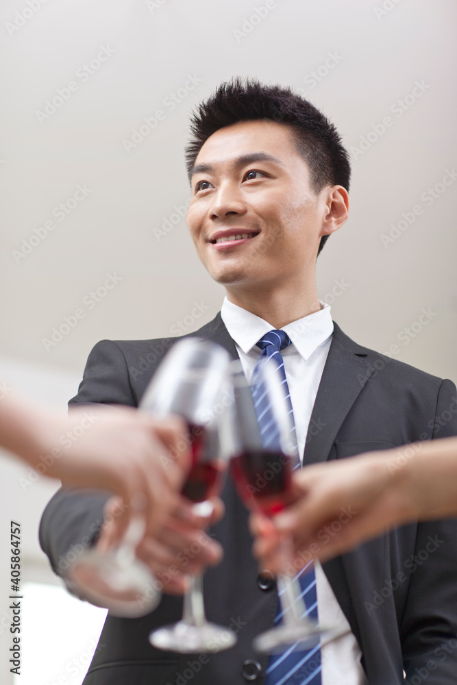 Portrait of businessman holding a glass of wine and toasting