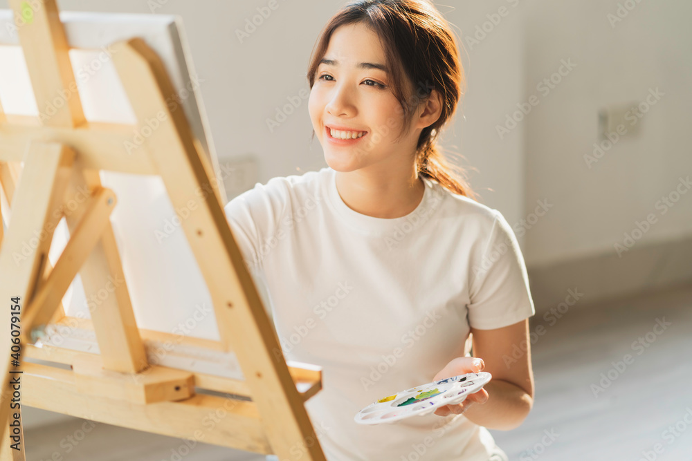 Young girl sitting on the floor learning to draw by herself