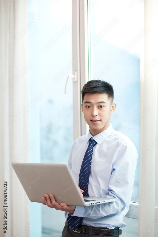 Portrait of young bisiness man with laptop