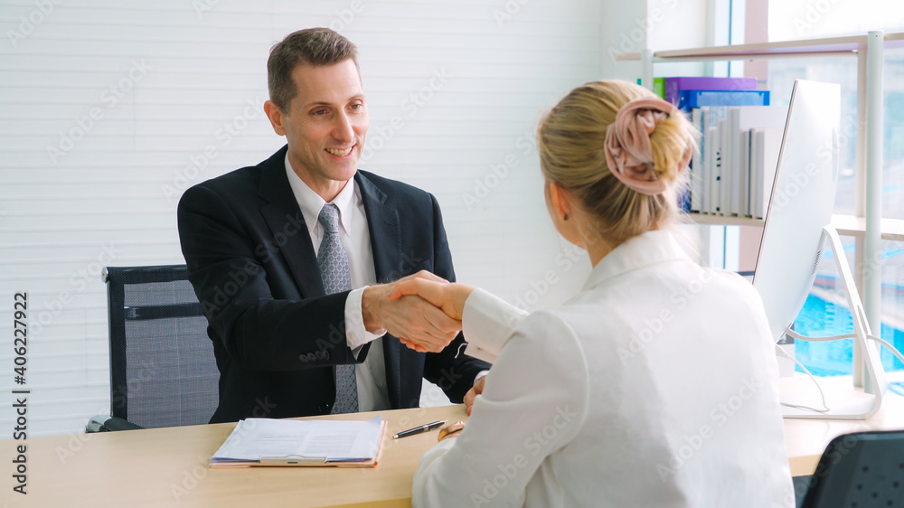 Job seeker and manager handshake in job interview meeting at corporate office. The young interviewee