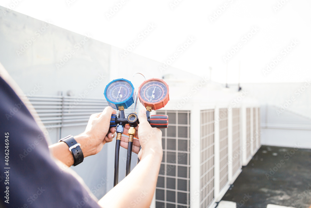 Technician is checking air conditioner ,measuring equipment for filling air conditioners.Cooling sys