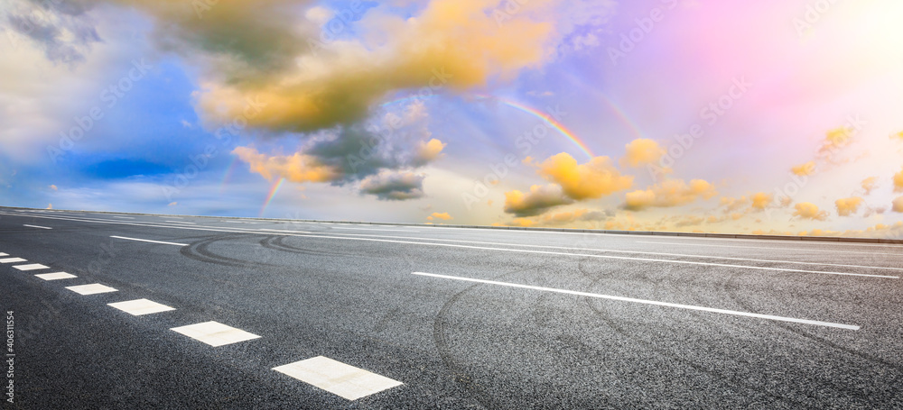 日落时的柏油路和天空云朵。道路背景。