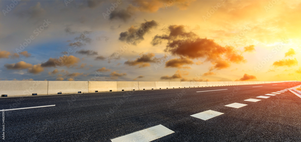 日落时的柏油路和天空云朵。道路背景。