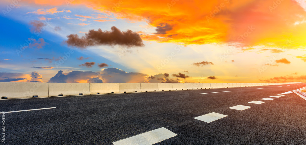 日落时的柏油路和天空云朵。道路背景。