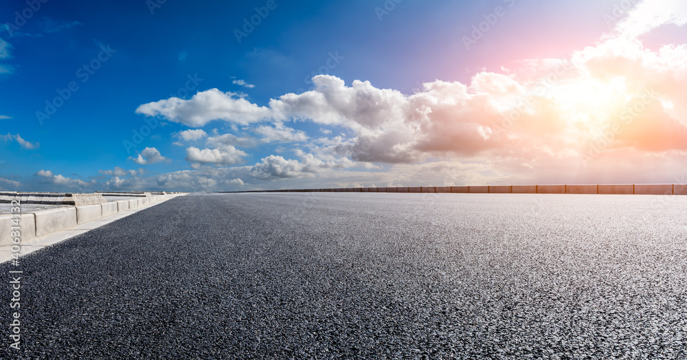 日落时的柏油路和天空云朵。道路背景。