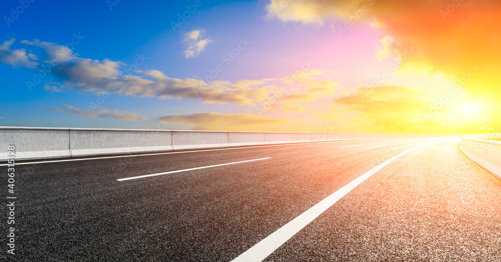 日落时的柏油路和天空云朵。道路背景。