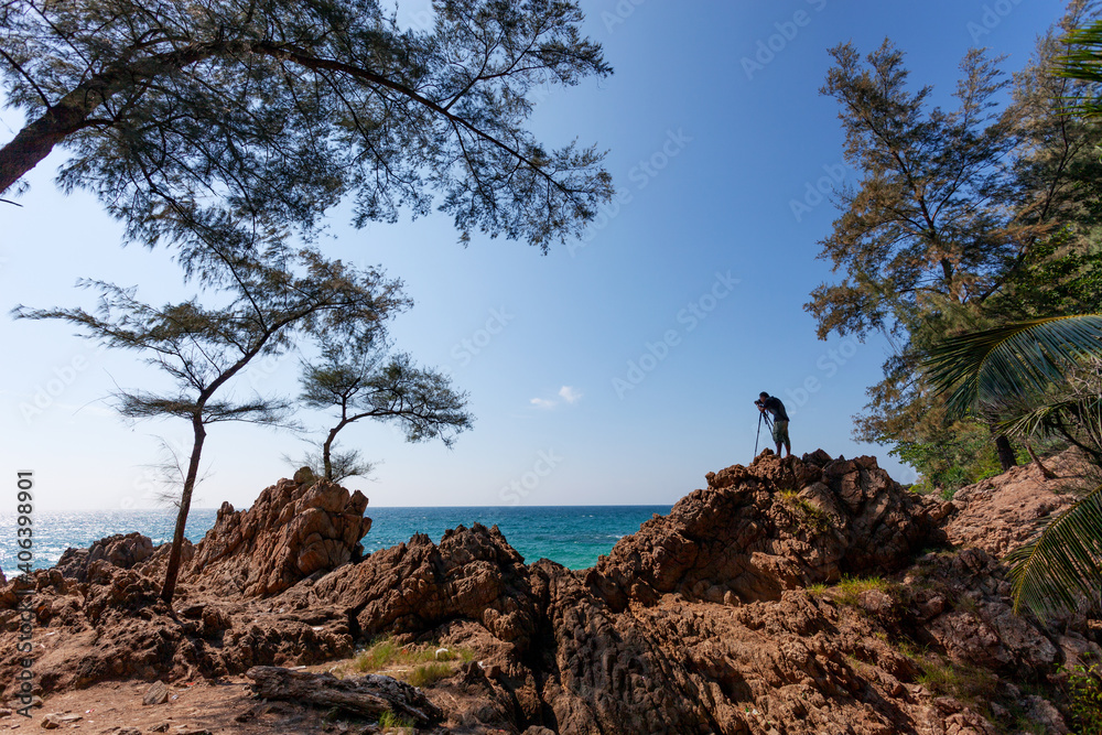 Photographer man standing on rock cliff have shooting session wild sea landscape