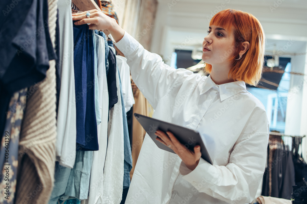 Woman taking clothes stock in her store