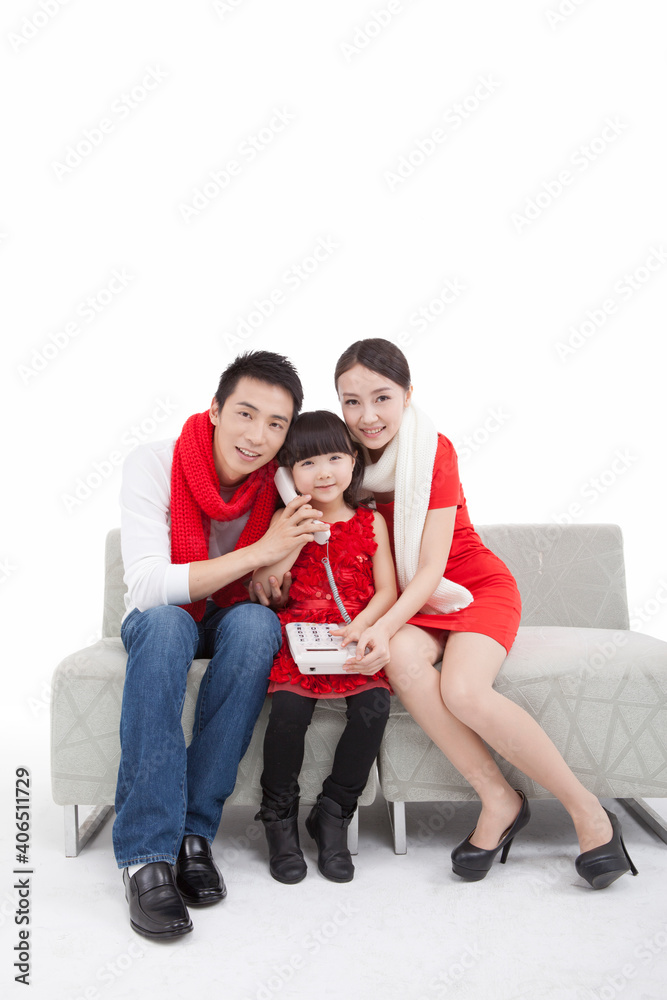 Portrait of daughter paying New Year call on telephone,with parents