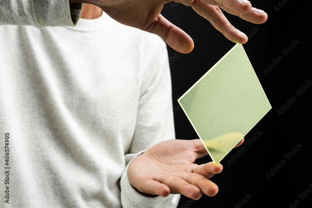 Man presenting yellow transparent plate futuristic technology